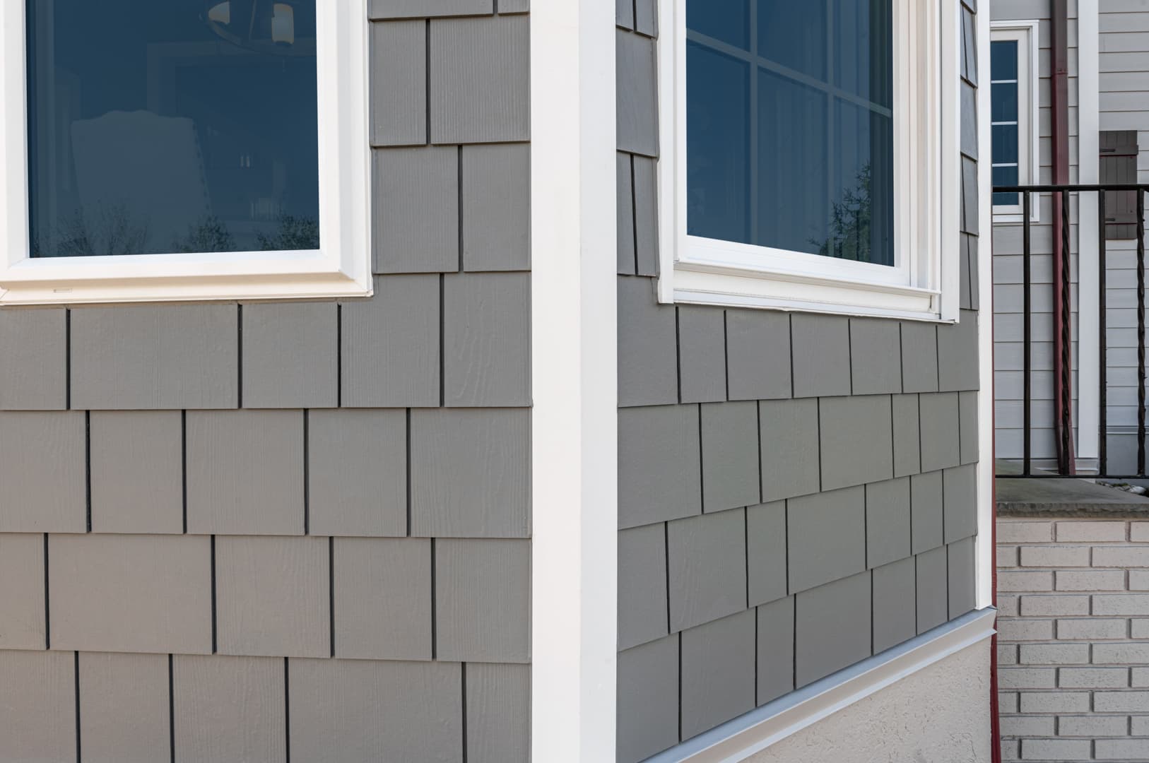 Cape Cod Style - A corner of a home featuring Pearl Gray shingles and Arctic White trim A corner of a home featuring Pearl Gray shingles and Arctic White trim
