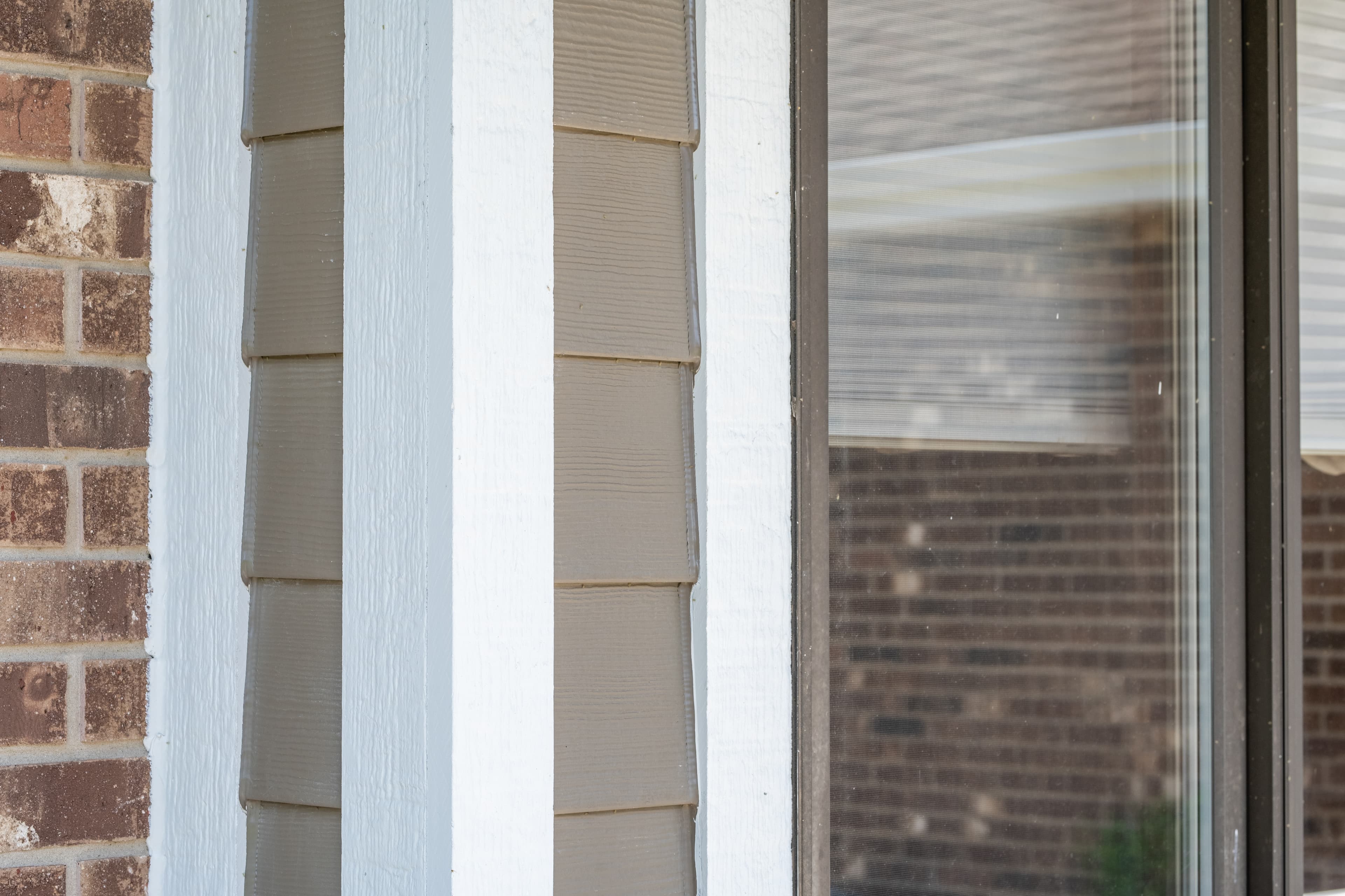 Selecting siding and trim for a whole house re-side: a detail image of a home featuring Hardie Plank in Timber Bark and Hardie Trim in Arctic White Detail of a home featuring Hardie Plank in Timber Bark and Hardie Trim in Arctic White