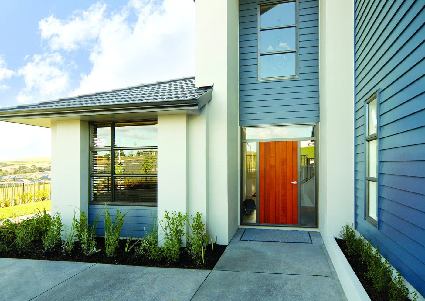 House with blue lap siding and an eye-catching orange door. House with blue lap siding and an eye-catching orange door.